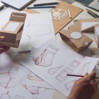 Designer sketching drawing design Brown craft cardboard paper product eco packaging mockup box development template package branding Label . designer studio concept .