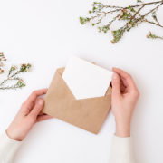 Woman's hands holding kraft envelope with blank wedding invitati
