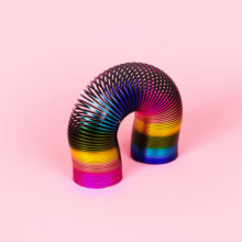 colorful slinky, retro toy over pink background, children's toy concept, panoramic image